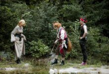 Fantasy characters engage in cosplay in a lush forest environment.