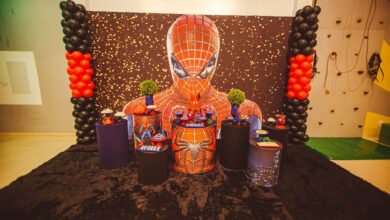 A colorful Spiderman themed birthday party decoration with balloons and figurines.