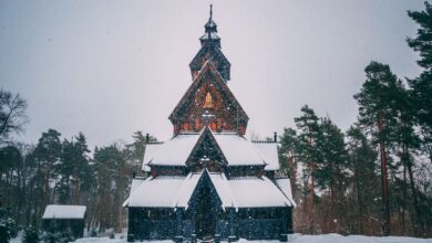Breathtaking view of a traditional Norwegian stave church surrounded by snow-covered trees in Oslo during winter.