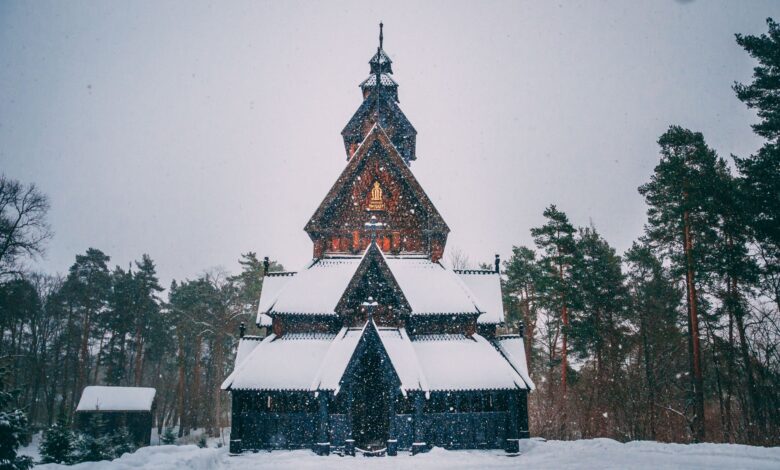 Breathtaking view of a traditional Norwegian stave church surrounded by snow-covered trees in Oslo during winter.