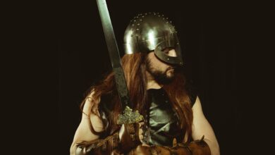 A medieval warrior wearing a helmet and leather armor, holding a sword, embodying the Viking spirit.