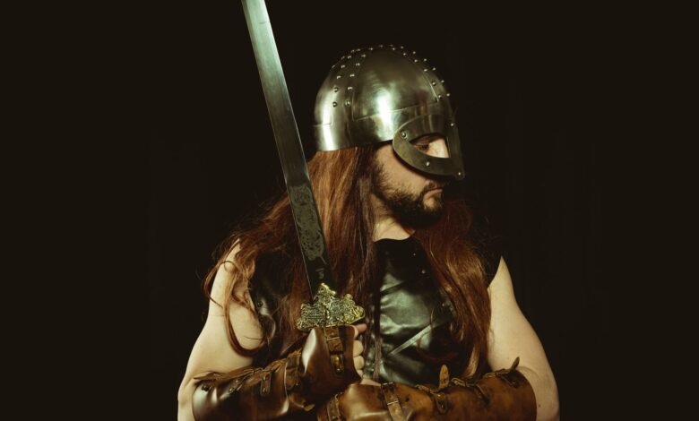 A medieval warrior wearing a helmet and leather armor, holding a sword, embodying the Viking spirit.