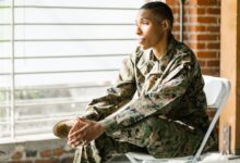 US veteran in uniform seated thoughtfully indoors, reflecting on mental health.