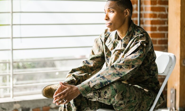 US veteran in uniform seated thoughtfully indoors, reflecting on mental health.