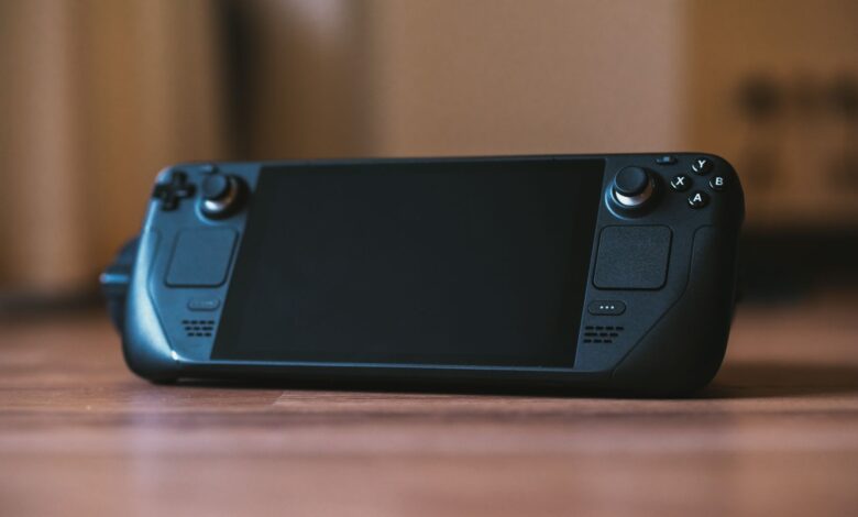 Modern handheld gaming console with buttons and joystick on a wooden surface, ideal for portable gaming enthusiasts.