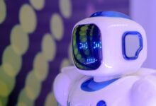 Close-up of a futuristic humanoid robot with a luminescent display in a modern setting.