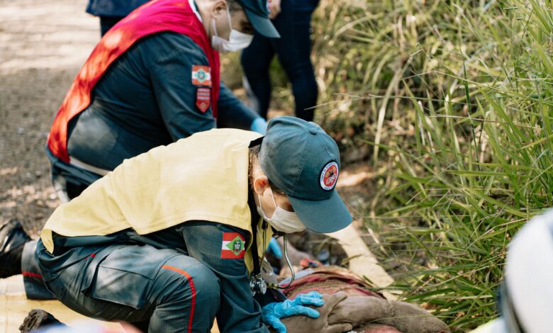 Emergency responders perform a life-saving simulation outdoors, demonstrating teamwork and first aid skills.