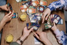 Close-up of friends playing a card game at a table, fostering socialization and togetherness.