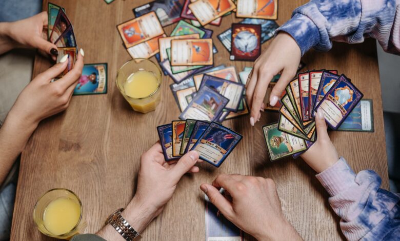 Close-up of friends playing a card game at a table, fostering socialization and togetherness.