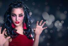 Enchanting woman with creative makeup poses in a mystical setting, perfect for Halloween themes.