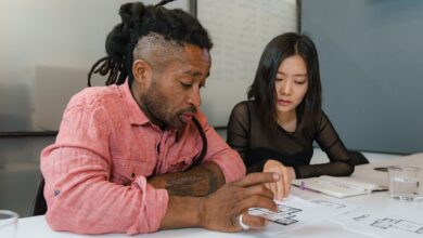 Two professionals engaged in planning during a business meeting, focusing on architectural designs.