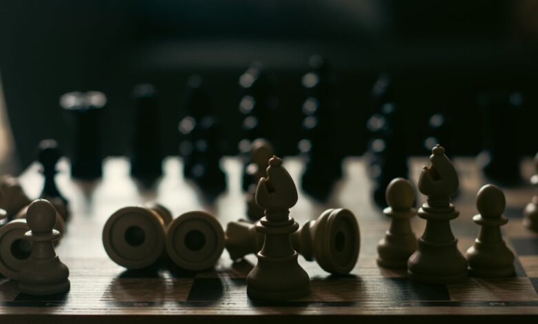 A dramatic representation of strategy and competition with chess pieces on a board.