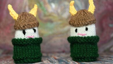 Two cute knitted Viking dolls with horned helmets in bright colors, perfect for crafts or decor.