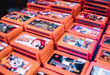 Close-up of stacked retro video game cartridges in orange cases, showcasing popular titles.