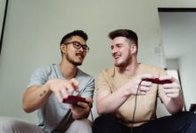 Two friends having fun playing video games in a relaxed home setting.