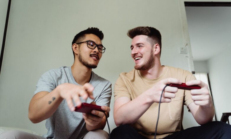 Two friends having fun playing video games in a relaxed home setting.